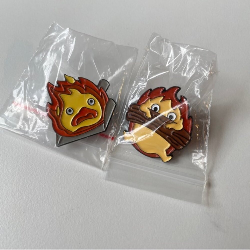 Two Calcifer enamel pins